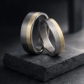 AH-Ślubna-2-Vigselring-i-titan-och-gulguld-med-diamant-0-02ct.webp
