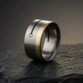 AH-Vagina-7-Vigselring-i-titan-och-gulguld-med-diamant-10-mm.webp